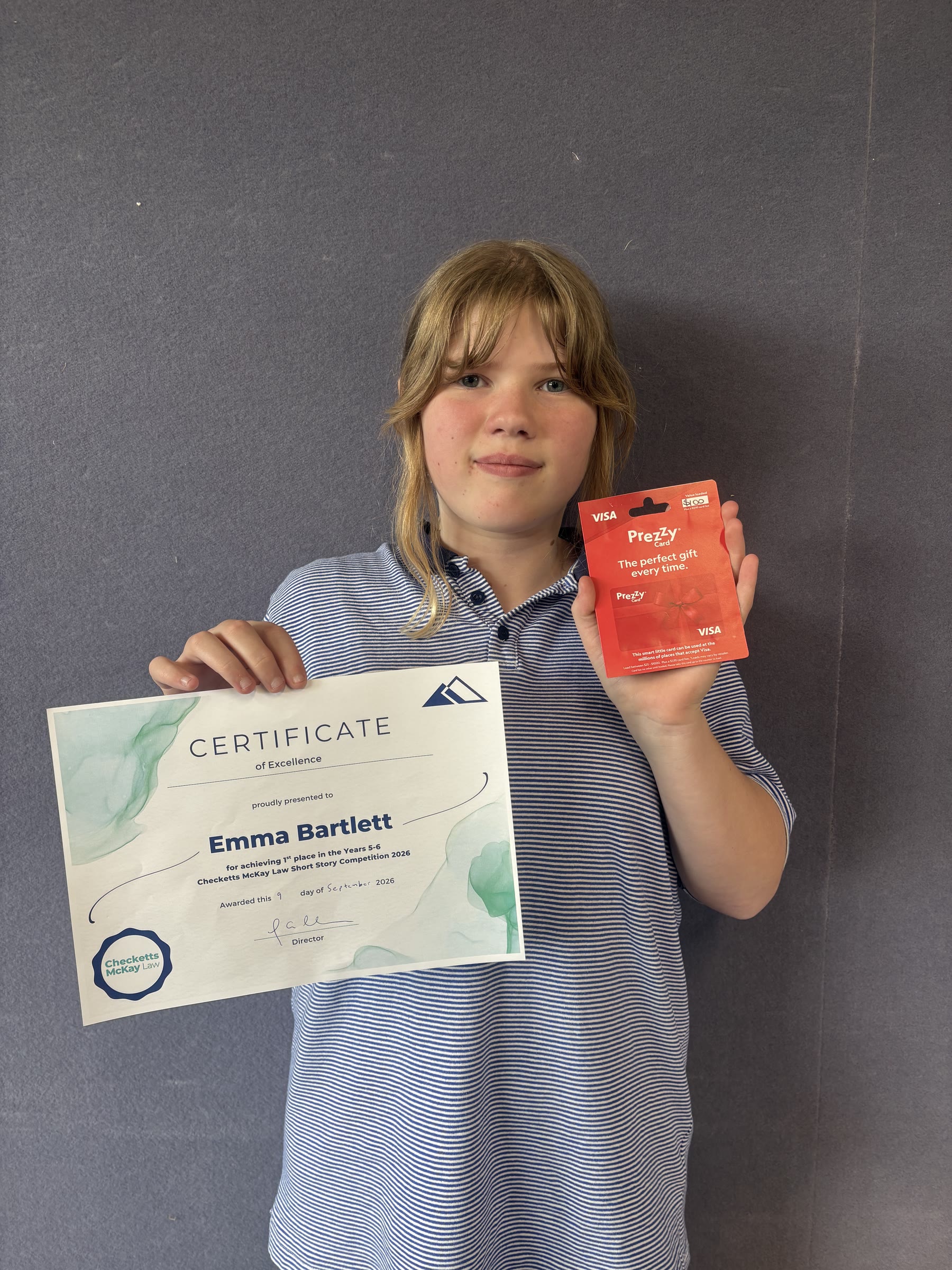 Emma Bartlett holding her first-place certificate and prize